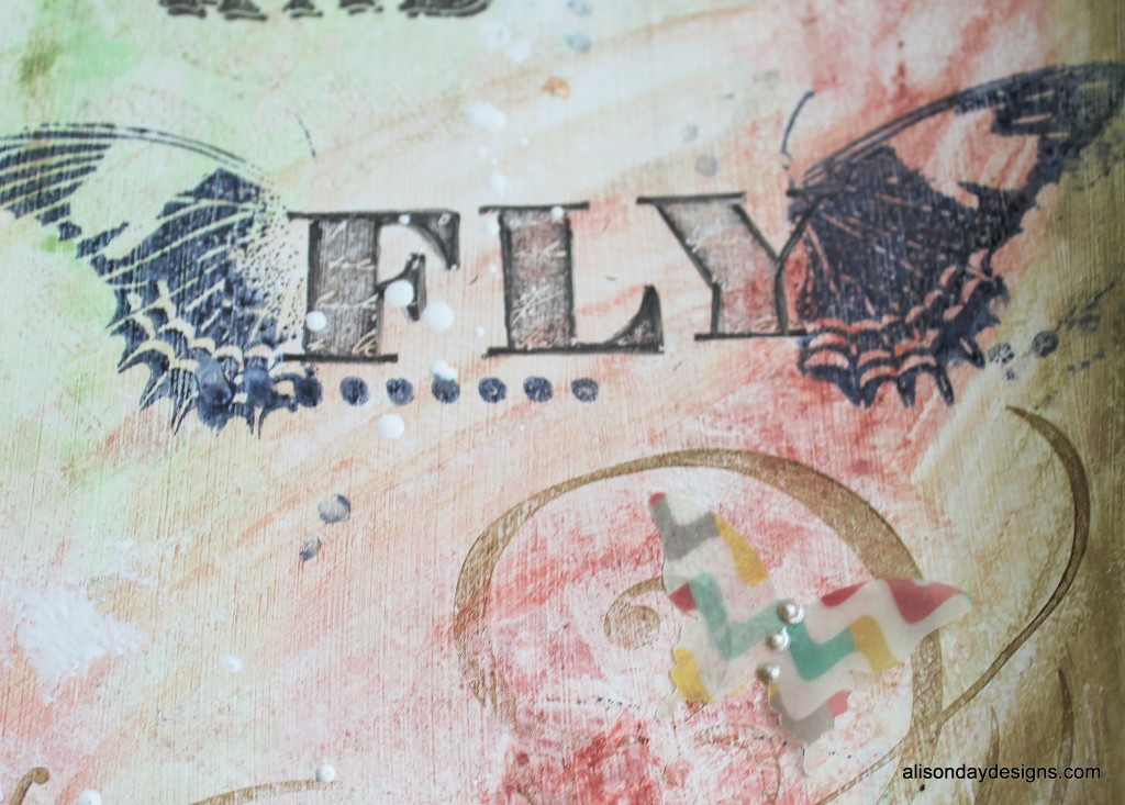 close up of 'FLY' with butterfly wings and paint splatters
